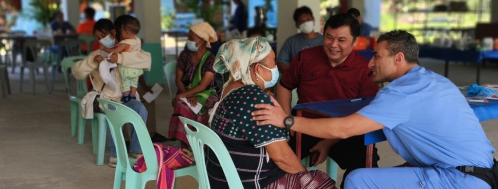 provider puts hand on shoulder of woman in mask