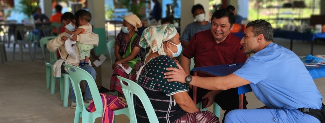 provider puts hand on shoulder of woman in mask